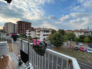 einen Balkon mit Blumen auf einer Stadtstraße in der Unterkunft Appartamento confortevole M.I. Casa in Cusano Milanino