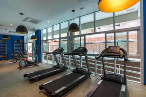 a gym with several treadmills in a room with windows at Estanconfor Santos com Vista Mar 7 AC Garagem alto 17º andar in Santos