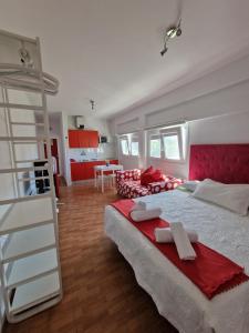 アガエテにあるApartamentos Los Chorrosのベッドルーム1室(大型ベッド1台、赤と白の家具付)