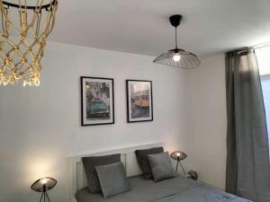 een slaapkamer met een bed en drie foto's aan de muur bij L’Adorable Gayant in Waziers
