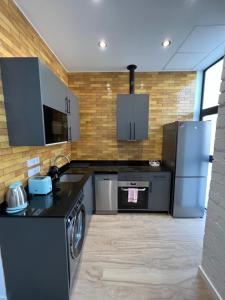 eine Küche mit schwarzen Arbeitsflächen und Küchengeräten aus Edelstahl in der Unterkunft Vip Apartments Valencia in Valencia