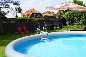 蘭斯克魯納的住宿－Brabo källare，一个带遮阳伞和庭院的大型游泳池