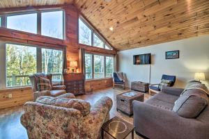 a living room with couches and chairs and windows at Stunning Monson Getaway on the Water! in Monson