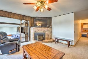 a living room with a fireplace and a ceiling fan at Lakeside Home with Deck Near Hunting and Fishing in Galmey