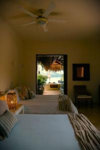 um quarto com 2 camas e uma ventoinha de tecto em Villa Luna Kuku em Zihuatanejo
