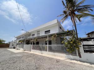 a white building with a palm tree in front of it at La Veleta in Playas