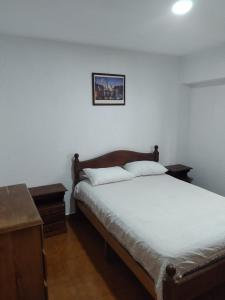 1 dormitorio con 1 cama y una foto en la pared en Departamento Parque Luro para 5 personas en Mar del Plata