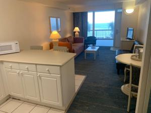 ein Wohnzimmer mit einem Sofa und einem Tisch in der Unterkunft The Conch Shell Oceanfront Condo in Daytona Beach