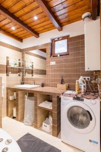 een badkamer met een wasmachine en een wastafel bij Erika's House. in Érd