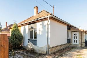 a white house with a gate and a fence at Erika's House. in Érd