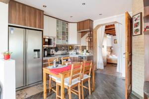 a kitchen with a wooden table and a refrigerator at Erika's House. in Érd