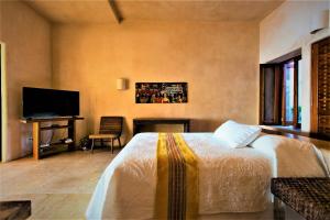 シワタネホにあるVilla Peninsulaのベッドと机とテレビのある寝室