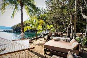 シワタネホにあるVilla Peninsulaのヤシの木と水のビーチのハンモック