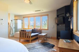 a living room with a couch and a tv at Gallatin River Lodge in Bozeman