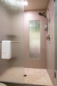 a shower with a glass door in a bathroom at Gallatin River Lodge in Bozeman