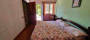 a bedroom with a bed with a flowered blanket on it at Hotel Las Brisas del Pacifico in Sámara