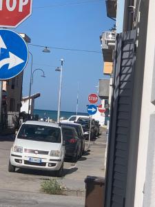 une rangée de voitures garées dans une rue avec un panneau d'arrêt dans l'établissement Appartamento Melissa, à Porto SantʼElpidio
