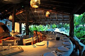 a dining room with a long table in a restaurant at Casa Las Gatas in Zihuatanejo