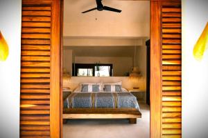 a bedroom with a bed and a ceiling fan at Casa Las Gatas in Zihuatanejo +55 photos