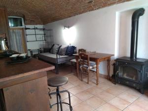 a kitchen and living room with a stove and a table at Mulino Valsorda in Magnano