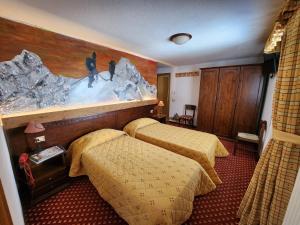 ein Hotelzimmer mit 2 Betten und einem Gemälde an der Wand in der Unterkunft Apartments Suites LAC BLEU in Breuil-Cervinia