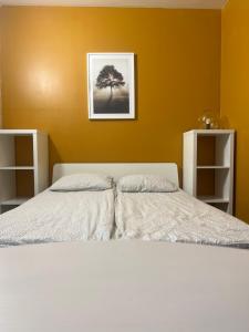sypialnia z białym łóżkiem i żółtą ścianą w obiekcie Apartment 202 w Gandawie