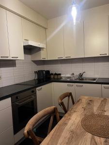 eine Küche mit weißen Schränken und einem Holztisch in der Unterkunft Apartment 202 in Gent