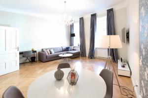 salon z białym stołem i kanapą w obiekcie Pink Grapefruit City Condo w Wiedniu