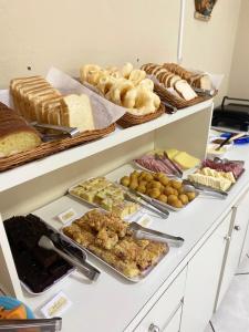a buffet filled with different types of bread and pastries at Pousada Arcanjo Rafael in Urubici