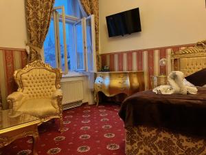 sypialnia z łóżkiem, krzesłem i telewizorem w obiekcie Hotel Klarinn Prague Castle w Pradze