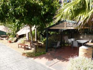 a patio with tables and chairs under a pavilion at The Balnarring Motel in Balnarring