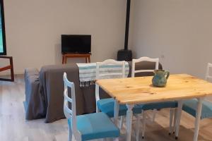 Una mesa y sillas de madera en una sala de estar. en Ohana del bosque, en Mar del Plata