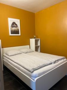 ein Schlafzimmer mit einem Bett in einer gelben Wand in der Unterkunft Apartment 202 in Gent