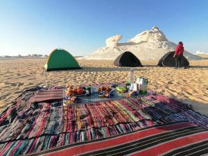 a blanket on the beach with tents on the sand at Western desert safari in Bawati