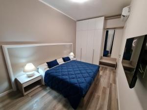 een slaapkamer met een blauw bed en een televisie bij Nel Sole Superior in Bologna