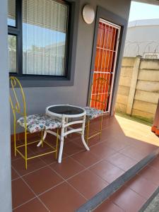 a patio with two chairs and a table and chairs at Ikhaya guesthouse2 in Pietermaritzburg