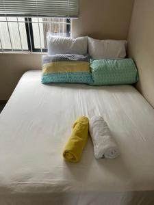 a bed with two towels sitting on top of it at Ikhaya guesthouse2 in Pietermaritzburg