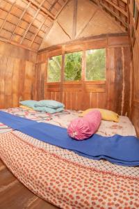 a bed in a wooden room with two pillows on it at Villa Kampung Ayem Riverside in Sleman