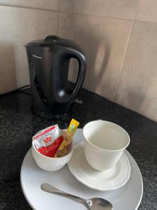 a plate with a coffee pot and a cup and a bowl at Ikhaya guesthouse2 in Pietermaritzburg