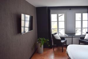 - une chambre avec un lit, un bureau et des fenêtres dans l'établissement Studio au Moulin " Design Noir " Vue Unique, à Dole