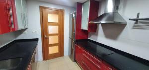 a kitchen with red cabinets and a black counter top at Gran piso cerca Centro Comercial y Playa in Ceuta