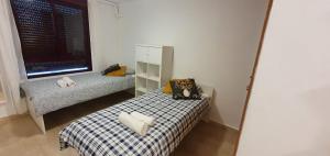 Habitación pequeña con cama y espejo. en Gran piso cerca Centro Comercial y Playa, en Ceuta