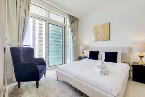 Un dormitorio con una cama grande y una silla azul. en Sunrise Bay 2 - Chic Two Bedroom, en Dubái