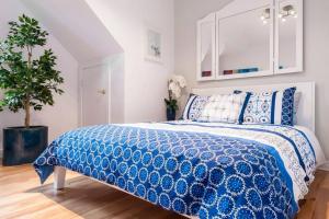 1 dormitorio con 1 cama con edredón azul y blanco en Le Metro Mont-Royal by HomeInMontreal, en Montreal