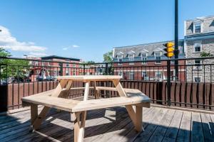 a wooden bench sitting on top of a deck at Le Metro Mont-Royal by HomeInMontreal in Montreal