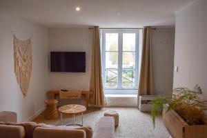 a living room with a couch and a large window at Studio au Moulin " La Plage " Vue unique sur la Petite Venise in Dole