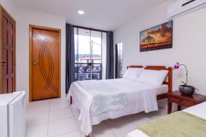 a hotel room with a bed and a window at Pousada Lagoa Azul in Paraty