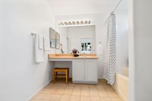 uma casa de banho com um lavatório e um toucador com um espelho. em @ Marbella Lane - Modern 4BR Home in Oro Valley em Oro Valley