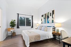 um quarto branco com uma cama, uma secretária e uma janela em @ Marbella Lane - Modern 4BR Home in Oro Valley em Oro Valley
