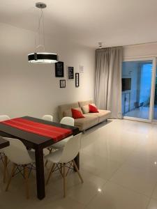 a living room with a table and a couch at Departamento Green Park in Punta del Este